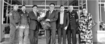  ??  ?? Mohd Aini standing (third left) hands Karim (standing centre) a souvenir from organisers of Samarahan Bike Challenge 2017 at his ministry after the press conference.