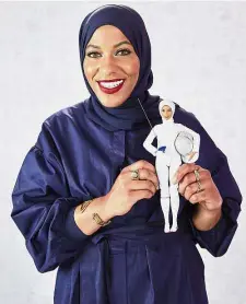  ??  ?? Ibtihaj holding the Barbie doll modelled after her likeness. — AFP Model athlete: