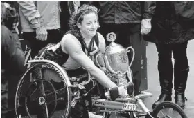  ?? MIKE LAWRIE/GETTY IMAGES ?? Clarksvill­e’s Tatyana McFadden (Atholton) holds the trophy after winning the women’s wheelchair division of the Boston Marathon for the third straight year.