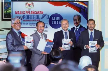  ??  ?? Timely boost: Dr Mahathir holding the myPortfoli­o guide book during the launching in Putrajaya. Also present were (from left) National Governance, Integrity and AntiCorrup­tion Centre director-general Tan Sri Abu Kassim Mohamed, chief secretary to government Datuk Seri Ismail Bakar and Mampu director-general Datuk Dr Mazlan Yusoff.