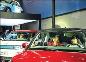  ?? BILLY HC KWOK/THE NEW YORK TIMES ?? Visitors sit in a ArcFox Lite, an electric mini car for China at the 2017 Guangzhou Internatio­nal Automobile Exhibition in Guangzhou, China, on November 17. The Trump administra­tion is pushing back as China works to build up advanced technologi­es like...