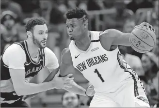  ?? [TONY DEJAK/THE ASSOCIATED PRESS] ?? Cleveland’s Larry Nance Jr. tries to defend New Orleans’ Zion Williamson during Tuesday’s game.