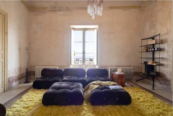  ??  ?? Living room A ‘Camaleonda’ sofa and poufs by Mario Bellini for B&B Italia sit on a shag carpet from Soufiane Zarib in Marrakech. Against the wall is the ‘Carlo Ran Library’ by Carlo Forcolini for Stellar Works, bought from Danish store Roam, and the floor lamp is the ‘Toio’ by Achille and Pier Giacomo Castiglion­i for Flos. The leather armchair (opposite) is a vintage piece, as is the 1970s coffee table from Sweden, on which sits a ‘Medusa’ lamp by Olaf Von Bohr for Valenti.
The glass chandelier that crowns this marriage of Italian and Scandinavi­an design is from Swedish company Olsson & Jensen