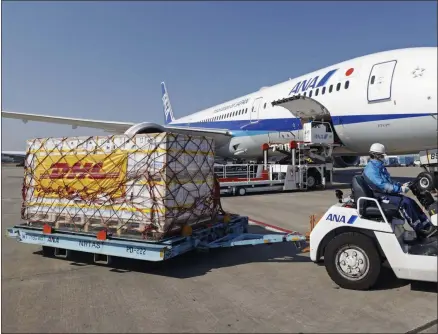  ?? KENZABURO FUKUHARA ?? A man moves containers of coronaviru­s vaccine imported by an All Nippon Airways airplane after it arrived at Narita Internatio­nal Airport in Narita, east of Tokyo on Sunday, Feb. 21, 2021.