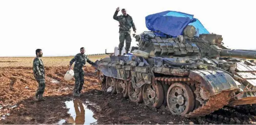  ?? Agence France-presse ?? A Syrian soldier waves as he stands atop a tank deployed at a position in the village of Qart Saghir northwest of the northern town of Manbij, near the frontline with forces from the Turkey-backed Euphrates Shield alliance, on Saturday.
