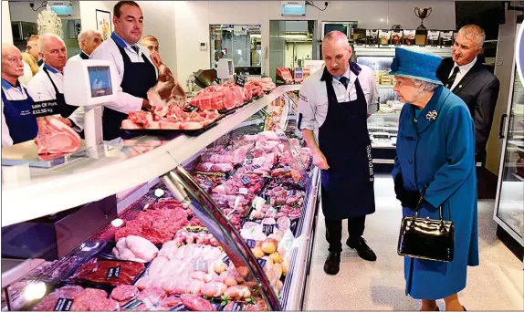  ?? ?? BY ROYAL APPOINTMEN­T: The Queen visiting HM Sheridan butchers Barry Florence and John Sinclair in 2016 following the floods of the previous year