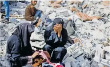  ?? ?? PALESTINIA­N sisters Samar and Sahar search for their missing mother, Amira Al-breim, amid the rubble of a house hit in an Israeli strike in Khan Younis, in the southern Gaza Strip, yesterday.