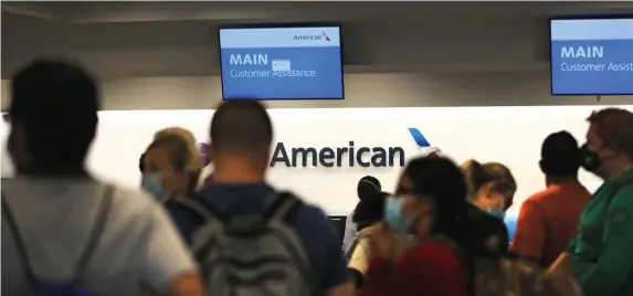  ?? NAncy lAnE / HErAld stAFF ?? QUEUING FOR DEPARTURE: Customers line up Monday at the American Airlines counter at Logan Internatio­nal Airport.