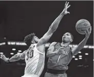  ?? AP PHOTO/ADAM HUNGER ?? Louisville guard Christen Cunningham (1) drives to the basket past Marquette forward Ed Morrow during the consolatio­n game of the NIT Season Tip-Off tournament. Marquette won 77-74 in overtime.