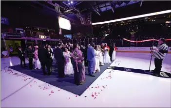  ?? LOVELAND REPORTER-HERALD FILE ?? Todd Harding, right, officiates Loveland’s annual Valentine’s Day group wedding and vow renewal ceremony in 2023. The 2024 event will take place at the Eagles hockey game at Blue Arena in Loveland.