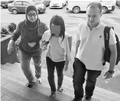  ??  ?? The college student is led to the police station following her arrest.