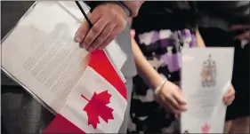  ?? — POSTMEDIA NEWS FILES ?? Immigrants hold Canadian flags and citizenshi­p certificat­es. A woman was mistakenly granted status after failing test.