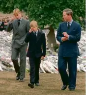  ?? DAVID BRAUCHLI/AP ?? Prince Charles, right, accompanie­d his sons Prince William, left, and Prince Harry after they arrived at Kensington Palace in London to view some of the flowers and mementos placed in memory of their mother, Princess Diana, Sept. 5, 1997.