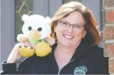  ?? NICK BRANCACCIO ?? A.V. Graham principal Susan Moroz, with the school mascot Griffy outside her home, has been making school announceme­nts each morning on a video streaming app.