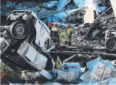  ??  ?? Wrecked vehicles lie amid rubble from the Morandi bridge in Genoa following its collapse on Tuesday.