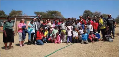  ??  ?? Love in Africa members with children and staff of a home in Zimbabwe