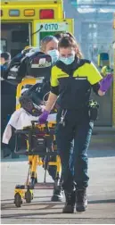  ?? MARIE-FRANCE COALLIER LE DEVOIR ?? Une ambulanciè­re masquée conduit un patient sur une civière à l’hôpital.