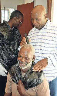  ?? CONTRIBUTE­D ?? Deputy Mayor Sidney Stewart trims a homeless man at the Drop-In Centre in Ocho Rios on World Homeless Day.