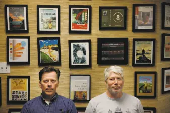  ??  ?? Grotto co-founders Ethan Watters (left) and Po Bronson stand in front of a wall that shows off some of the works that have come out of their community of scribes.