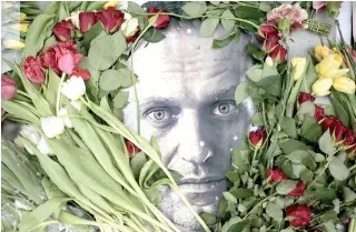  ?? (Photo by AFP) ?? Flowers are placed around a portrait of the late Russian opposition leader Alexei Navalny at a makeshift memorial in front of the former Russian consulate in Frankfurt am Main, western Germany, on February 19, 2024.