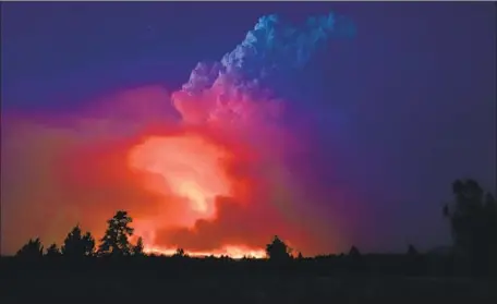  ?? John Hendricks Oregon Office of the State Fire Marshal ?? FLAMES AND SMOKE rise from southern Oregon’s Bootleg fire last week. “We’re seeing things we’ve never seen before,” one longtime firefighte­r said of the blaze, which has absorbed a smaller fire and created its own lightning as it moves toward mountain towns.