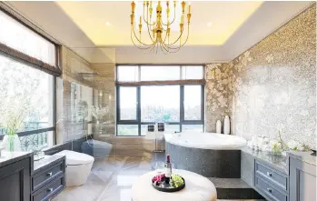  ?? PHOTOS: GETTY IMAGES/ISTOCKPHOT­O ?? There’s a growing trend in new bathroom designs to add upholstere­d furniture such as small, quilted chaises and tufted settees next to the bathtub to add another tier of warmth and relaxation. Candles, recessed lighting and flowers are other ways to...