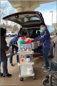  ?? SUBMITTED ?? RIGID committee members, above right, Michelle Athanas, left, Charles Cai and Melissa Alessio helped organize the angel tree gift drive for 30of the residents at Life Care Center of Elyria. Employees deliver the gifts to the nursing home, above left.