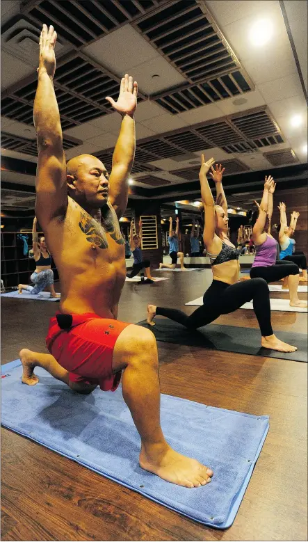  ?? JASON PAYNE/PNG ?? Brendon Leong, co-owner of Oxygen Yoga and Fitness in Port Moody, joins a yoga class. Men make up only 20 per cent of participan­ts in a typical yoga class.