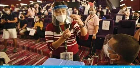  ??  ?? MANILA: A health worker prepares a vial of Chinese Sinovac vaccine against COVID-19 disease inside a movie theatre turned into a vaccinatio­n center in Taguig City suburban Manila yesterday. —AFP