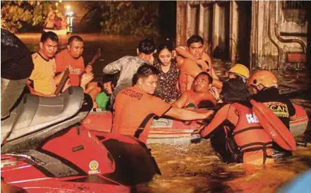  ?? AFP PIC ?? Rescue personnel evacuating flood-affected residents in Davao, Mindanao, yesterday, after Tropical Storm Tembin dumped torrential rains across the island.