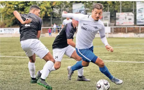  ?? RP-FOTO: RALPH MATZERATH ?? Die Hildener Justin Härtel (l.) und David Szewczyk versuchen mit aller Macht, den Baumberger Roberto Guirino von Ball zu trennen.