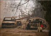  ?? JUSTIN SULLIVAN / GETTY IMAGES ?? Power lines rest on cars that were burned by the Camp Fire on Saturday in Paradise, Calif. The fire has destroyed more than 6,700 homes and businesses.