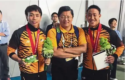  ??  ?? Good outing: Coach Yang Zhuliang (centre) posing for a photo with Chew Yiwei (left) and Ooi Tze Liang after they won silver in the men’s 3m springboar­d synchro at the Asian Swimming Championsh­ips in Tokyo on Thursday.