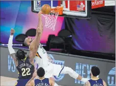  ?? Ashley Landis The Associated Press ?? Utah’s Rudy Gobert (27) is fouled by New Orleans’ Derrick Favors (22) on a dunk, setting up Gobert’s winning free throws with 6.9 seconds left.