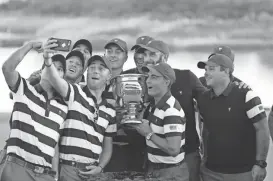  ?? BILL STREICHER/USA TODAY SPORTS ?? U.S. team members pose for a selfie after defeating the Internatio­nal team in the Presidents Cup at Liberty National Golf Course in Jersey City, N.J., on Sunday.