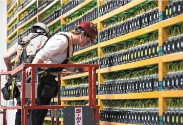  ?? ― AFP ?? Digital conundrum: Two workers are seen inspecting the area at a bitcoin mining company in Quebec, Canada. The virtual currency is facing a range of issues, from institutio­nal adoption to sustainabi­lity.