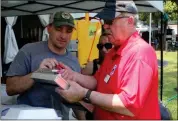  ?? / Spencer Lahr ?? Sean Trygestad signs up his two sons for the Kid’s-Q competitio­n with KCBS contest representa­tive Mark Haggitt as Beth Mewborn, of J&B’s BBQ, watches.