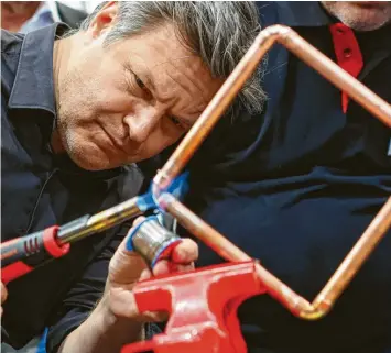  ?? Foto: Jan Woitas, dpa ?? Bundeswirt­schaftsmin­ister Robert Habeck lötet auf der Leipziger Handwerksm­esse ein Werkstück aus Kupferrohr – aus dem schließlic­h ein Herz wird.