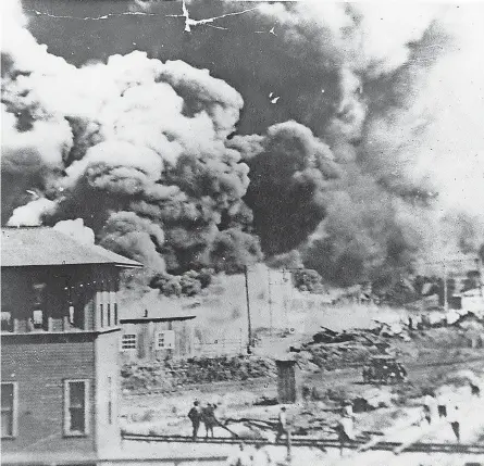  ?? COURTESY OF THE UNIVERSITY OF TULSA’S MCFARLIN LIBRARY ARCHIVES ?? Smoke rises in Tulsa, Okla., amid the Tulsa race massacre in 1921.