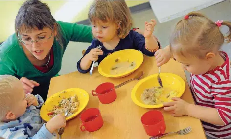  ?? FOTO: DPA ?? Erzieherin­nen kümmern sich in Kindertage­sstätten intensiv um den Nachwuchs. Doch dafür müssen die Eltern tief in die Tasche greifen.