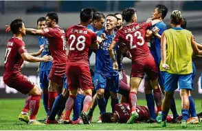  ??  ?? Free-for-all: A brawl erupting between Shanghai SIPG (in red) and Guangzhou R&F players as Oscar lies on the ground in the Chinese Super League match on June 18.