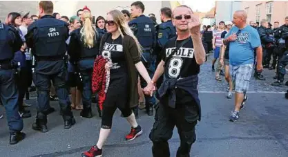  ?? Foto: AP/C. Essler ?? Teilnehmer des „Schild und Schwert“-Festivals in Ostritz tragen ihre Gesinnung auf T-Shirts zur Schau.