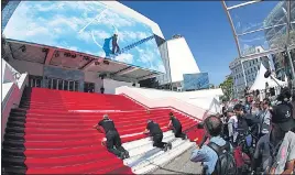  ?? REUTERS ?? Workers install the red carpet in front of the main entrance of the Festival Palace on the day of the opening ceremony of the film festival, on Tuesday.