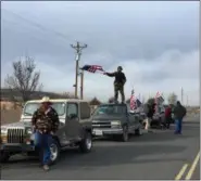  ?? REBECCA BOONE — ASSOCIATED PRESS ?? People wave American flags Thursday near the Malheur National Wildlife Refuge in Oregon.