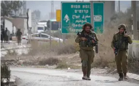  ?? (Nasser Ishtayeh/Flash90) ?? SOLDIERS PATROL near the scene where a Palestinia­n assailant stabbed two people yesterday at the entrance to .