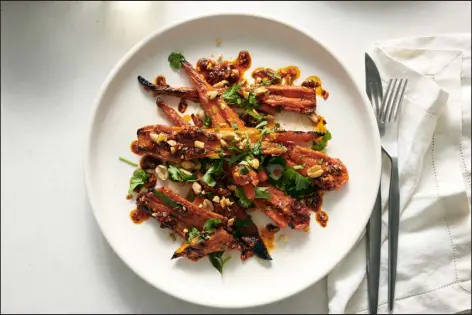  ?? PHOTOS BY DAVID MALOSH — THE NEW YORK TIMES ?? A winter salad, which pairs Asian smashed cucumbers with crushed carrots topped with vinegar, soy sauce, sesame and ginger,