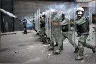  ?? AP/ARIANA CUBILLOS ?? Members of the Bolivarian National Guard block protesters Wednesday in downtown Caracas, Venezuela. As protests persist against the government of President Nicolas Maduro, internatio­nal pressure to schedule delayed regional elections and to free...