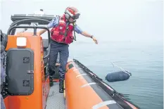  ??  ?? Brad Lavantis of Port Weller Search and Rescue tosses a buoy into the water as a demonstrat­ion of how hard it is to find objects or people in the water.