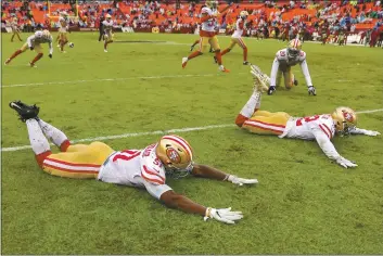  ?? PATRICK SMITH — GETTY IMAGES ?? 49ers players’ Azeez Al-shaair (51), D.J. Reed (32) and teammates slide on a rain-soaked field after defeating Washington last season.