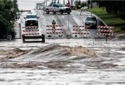  ?? William Luther / Staff photograph­er ?? Leon Creek poured over Pinn Road south of Texas 151 on the city’s West Side on Tuesday after heavy rains pummeled the area.